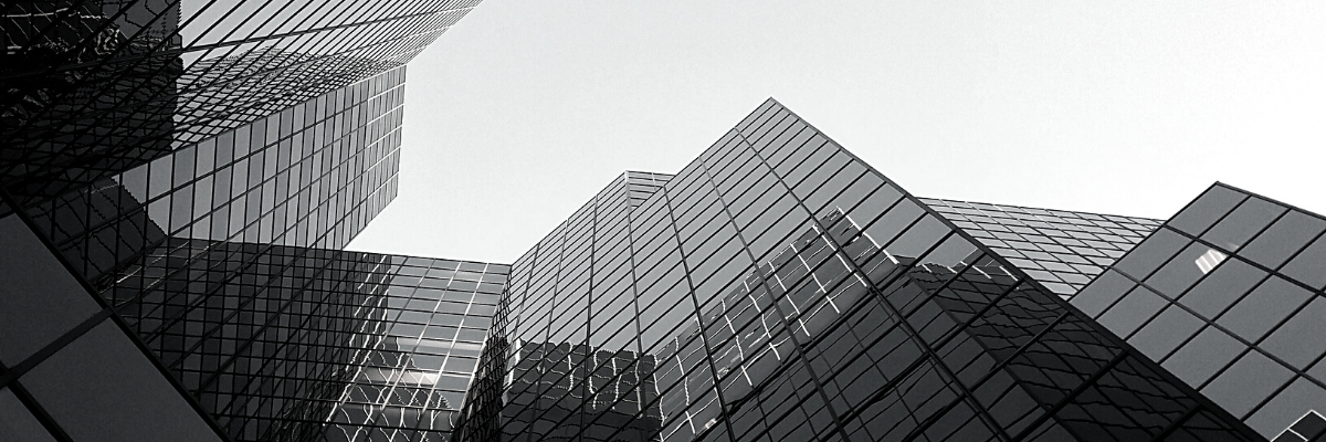 a black and white photo of a building with glass facades