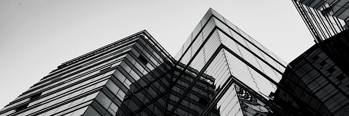 a black and white photo of a building with glass facades