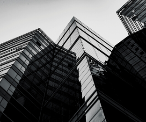 a black and white photo of a building with glass facades
