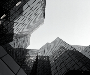a smaller black and white photo of a building with glass facades