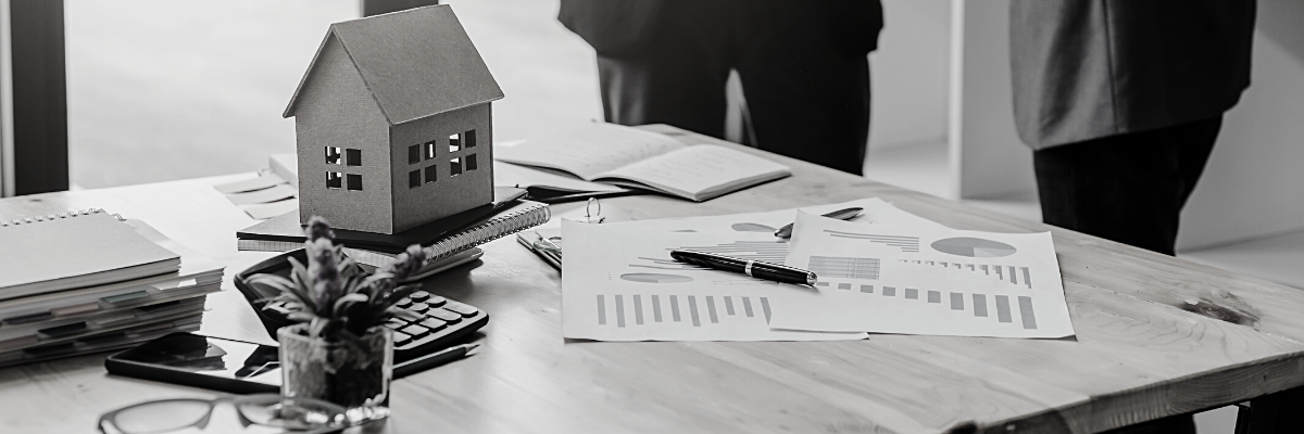 a black and white photo of two people consulting financial reports