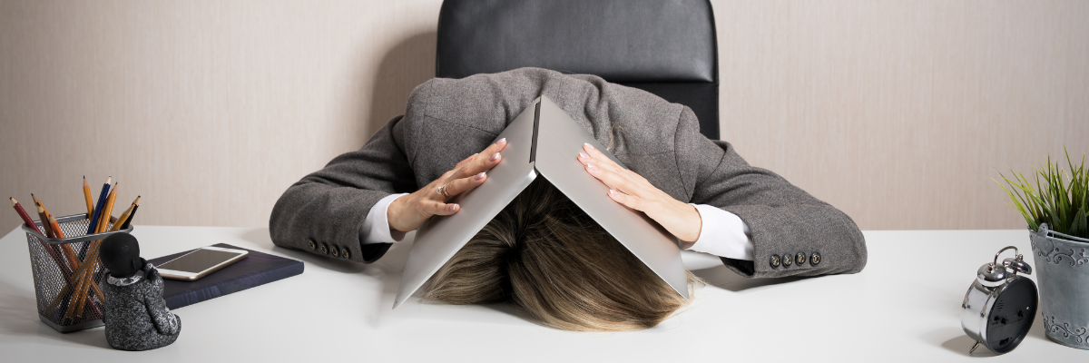 a person sitting at a desk with their head in a book