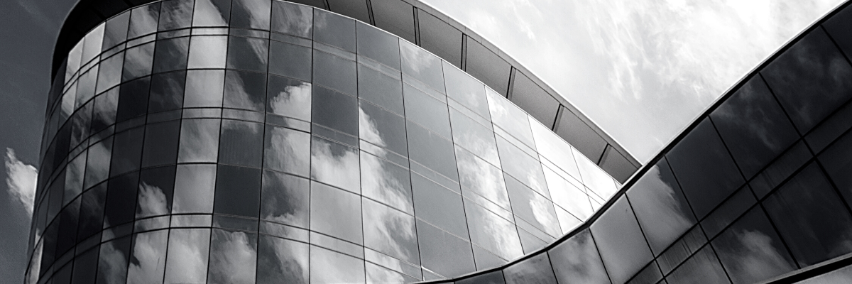 a black and white photo of a modern building with glass facades