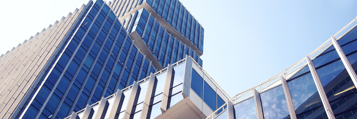 a colour photo of some tall buildings full of glass fascades next to each other