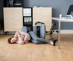 a woman laying on the floor next to a desk