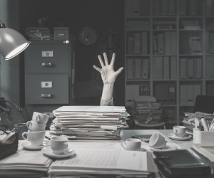 a black and white photo of someone showingtheir hand above a load of files