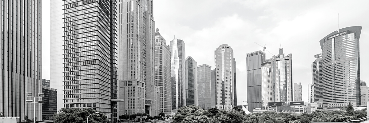 a landscape black and white photo of a corporate city with trees in the middle of the business area
