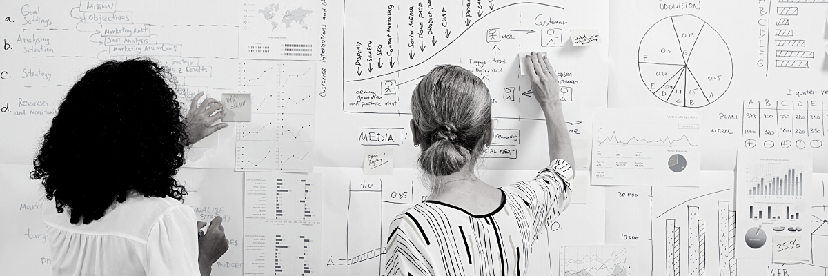 a black and white photo of two ladies looking at financial management original