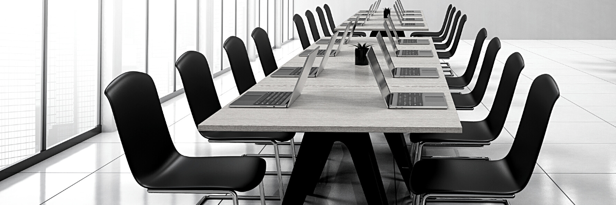 a black and white photo of a boardroom filled with laptops and chairs original