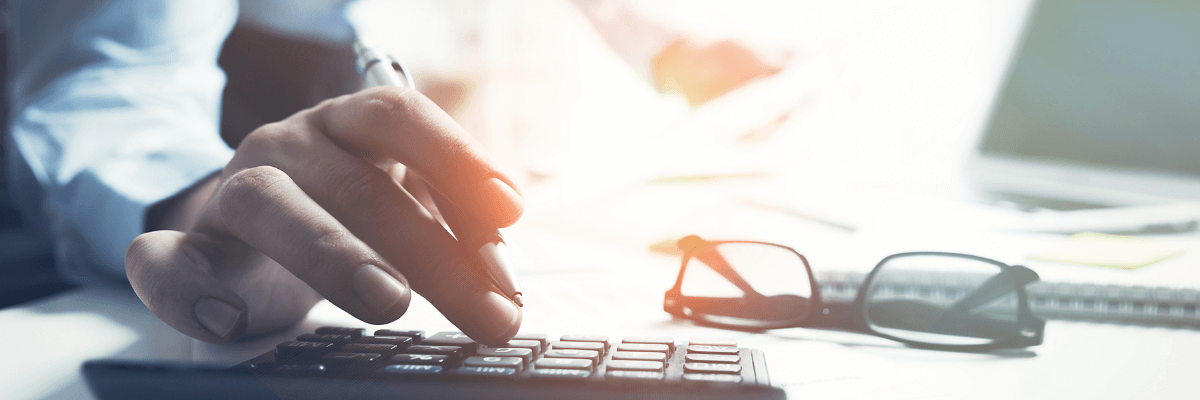 a colour photo of an accountant working on a calculator